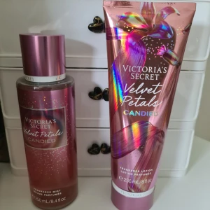 Victoria's Secret Velvet Petals Candied - Set med Velvet Petals Candied från Victoria's Secret, innehåller en rosa skimrande body mist (250 ml) och en matchande lotion (236 ml). Doften har inslag av karamell och blommiga toner. Flaskan och tuben har metallic-rosa finish med holografiska detaljer. Helt nytt och oanvänt. Svarar ej på förhandlingar 