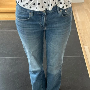 Blå bootcut jeans från lager 157 - Snygga blå jeans från lager 157 som är uppsprättade i benen med fickor med knappar! Modell short men som sagt uppsprättade 