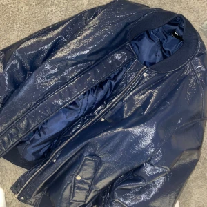 Blank oversized bomberjacka från ASOS - Blank oversized bomberjacka från asos i marinblå polyester. Fodrad på insidan. Två fickor på sidan som gör att stånga med en knapp. Jackan stängs med dragkedja och knappar. Ingen luva. Inga innerfickor. Nypris 999kr 💙Storlek 38. Använd fåtal gånger.