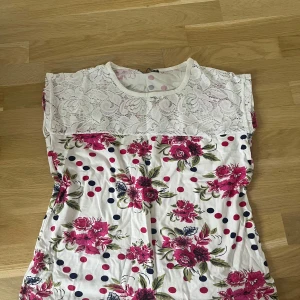 Blommig topp från Moda Katalinsci - Snygg topp med spets i överdel. Inga defekter. Säljer då den tyvärr inte passar mig. 