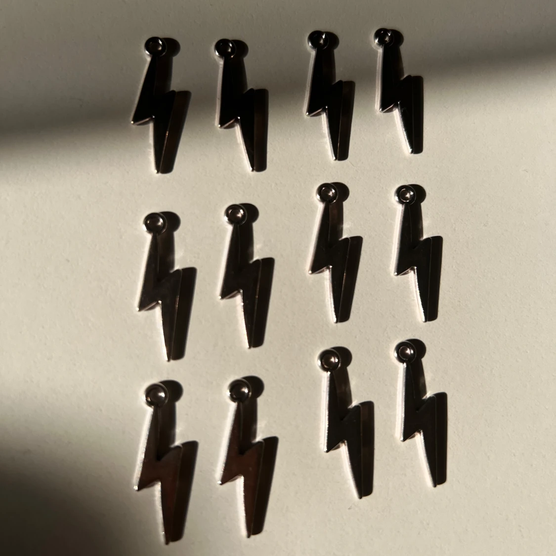 Blixtformade silvriga berlocker 