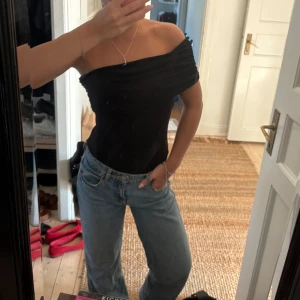 One shoulder body  - Säljer en svart offshoulder topp från H&M i storlek S. Toppen har en draperad design och är figurnära med en axelbandslös passform. Använd en gång säljer pågrund av har många liknande. 