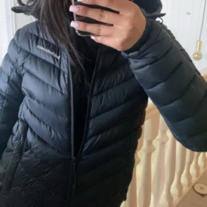 Svart dunjacka Peak Performance - Säljer en svart dunjacka från Peak Performance med huva och dragkedja. Jackan har snygga diagonala sömmar och logga på bröstet. Perfekt för kalla dagar och riktigt skön att ha på sig. Passformen är normal och jackan är långärmad.🩷 Köpte jackan för orginal pris som var runt 2800kr men priset kan diskuteras 🩷