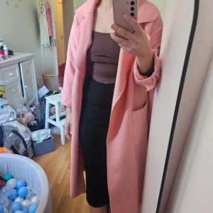 Rosa kappa från NLY Trend med bälte - Säljer en lång, oversized rosa kappa från NLY Trend. Storlek 36 men den är rymlig. I fint skick och riktigt härlig rosa färg