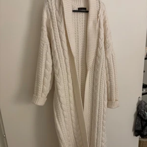 Varm tjock vävd maxikofta vit/cream - Mycket gott skick- mindre noppor som kan tas bort. Etiketten säger M och den sitter så.  Nypris: 662kr Bra kvalité och väldigt varm Liknar den populära Zara koftan från förra årets kollektion