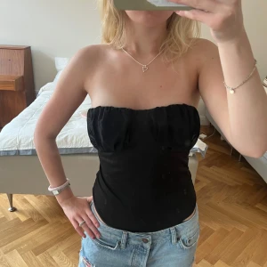 Svart body med smala axelband - Säljer en svart body med smala, justerbara axelband som kan bäras både med och utan axelband.