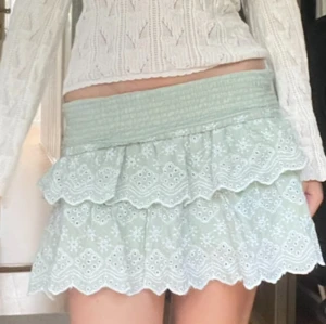 Mintgrön volangkjol med broderi - Superfin mintgrön kortkjol med broderade vita blommor och två lager volanger. Kjolen har bred smock i midjan för en bekväm passform och är gjord i mjuk bomull. Perfekt för dig som vill ha en söt och somrig look! Pris går att diskuteras vid snabbt köp 💕 skriv vid frågor!