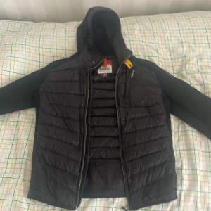 Svart pufferjacka Parajumpers S - Säljer en svart pufferjacka från Parajumpers i storlek S köpt från Johnells . Jackan har huva, quiltad framsida och rygg, samt släta svarta ärmar. Ny pris 4100kr. Möts i Stockholm.  Nästan som ny. Kan gå ner i pris mellan dessa datum 16/06-26/06. Utöver de datum går men inte lika mycket kampanjveckan nu. Äkta såklart 