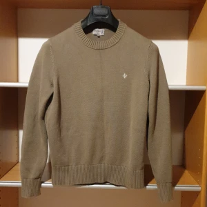 Olivgrön stickad tröja från Morris XS - Snygg olivgrön stickad bomullströja från Morris i storlek XS. Tröjan har rund halsringning och ribbade muddar.