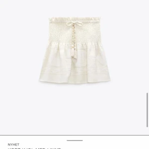 Kjol - Säljer en supersöt vit/beige kjol med smockad midja och snörning framtill. Kjolen är helt oanvänd och säljs inte längre. Köpt för 399kr.😊🤗