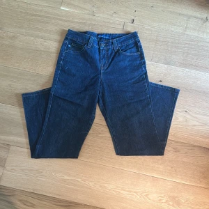 Mörkblå jeans från Bandolino Blu - Snygga mörkblå jeans från Bandolino Blu med klassisk femficksdesign och raka ben. Jeansen har normal passform och är tillverkade i ett mjukt denimtyg som sitter skönt hela dagen. Perfekta till sneakers eller boots. 