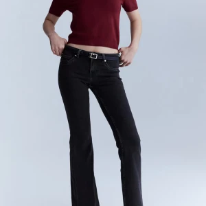 Svarta bootcut jeans med låg midja - Snygga svarta jeans med bootcut-snitt och låg midja. Jeansen har klassiska fem fickor, bälteshällor och är tillverkade i stretchig denim för en bekväm passform. Perfekta för dig som gillar en retro vibe och vill ha ett par jeans som sticker ut. (Slutsåld på hm)