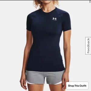 Compression t-shirt från Under Armour - Sportig mörkblå t-shirt från Under Armour med vit logga på bröstet. Modellen är tight och har korta ärmar, perfekt för träning. Mycket bra skick!