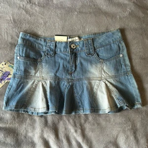 Blå kort volang Lågmidjad jeanskjol - Säljer den sötaste jeanskjolen med volanger som är kort och Lågmidjad. Storlek XS. Helt ny skick med lappar kvar, säljer då den inte kommit till användning. Supersnygg och perfekt till sommaren❤️