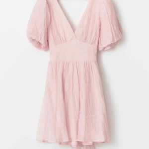 Rosa klänning - Rosa klänning från Gina Tricot som man knyter bak. Använd 1 gång. Slutsåld på hemsidan!                Modellen heter Bow Dress.                                                   Man får välja en eller flera varor för max 100kr vid köp över 500kr!