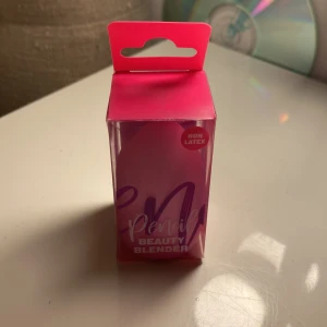 Pencil Beauty Blender rosa - En rosa beauty blender från Pencil, perfekt för att applicera foundation eller concealer. Den är tillverkad i ett mjukt, icke-latex material och kommer i en snygg förpackning. Formen är klassisk droppformad för enkel användning.
