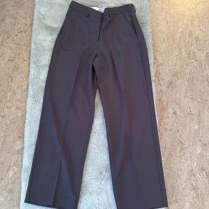 Grå kostymbyxor från JJXX, wide fit - Snygga grå kostymbyxor från JJXX i modellen JXMARY HW PANT. Byxorna har hög midja, vida ben och klassiska pressveck. Perfekta för en clean och stilren look. Färg: asphalt. Materialet är mjukt och följsamt tyg. Bought it a while back on Zalando, but I ended up not liking how the waist fits on me! Couldn’t return it cause I cut off the tag🫣it’s selling for 531kr on Zalando currently but I have it for 350kr (but the price can definitely be negotiated) 🤭🫶🏾