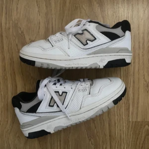 New Balance 550 sneakers  - New Balance 550 sneakers i vitt med svarta och grå detaljer. Köpt från en annan säljare, dock helt oanvänd av mig så säljer den i samma skick som den var köpt. Finns små defekter (se bild 5) som inte är så synliga men annars väldigt bra skick! 