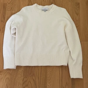 Vit stickad tröja från & Other Stories - Klassisk vit stickad tröja från & Other Stories med rund halsringning och breda ribbade muddar vid ärmslut och nederkant. Använd ca 3 gånger så i väldigt fint skick. Vid frågor är det bara att höra av sig🤍