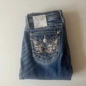 Miss Me jeans med paljettfjäril, mid-rise - Säljer mina Miss me jeans Mid - Rise bootcut i strl 24 / 32 pga av felköp. Jag har endast provat dem, alltså är dem helt nya fast utan prislapp - i nyskick! Köptes för 2300 kr