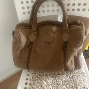Brun mocka handväska Zadig & Voltaire - Snygg brun handväska från Zadig Voltaire, har gått upp lite på handtaget och lite smutsigt men annars bra skick.