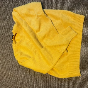 Gul stickad tröja från Uniqlo XS - Säljer en solgul stickad tröja från Uniqlo i storlek XS. Tröjan har rund halsringning, ribbade muddar och ärmar i klassisk modell. Perfekt för att liva upp garderoben med en färgklick!