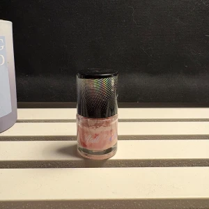 Ljusrosa nagellack med svart lock - Säljer ett ljusrosa nagellack i glasflaska med ett coolt svart lock med holografiskt prickmönster. Perfekt för dig som gillar en fräsch och naturlig look på naglarna. Liten och smidig flaska som är enkel att ta med i väskan.