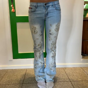 Låga ljusblå jeans med detaljer - Säljer dessa så snygga jeansen med jätte coola detaljer framtid från märket wanli. 💕💕 låga och bootcut. Midjemått: 39cm (passar säkert lite mindre och lite större då de är ganska stretchiga). Innerbenslängd: 83cm