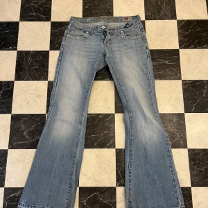 Ljusblå bootcut jeans  - Snygga ljusblå low waist jeans förutom att dragkedjan är lite sönder. Men skulle inte säga at man märker det på något sätt när man har på sig dom. 