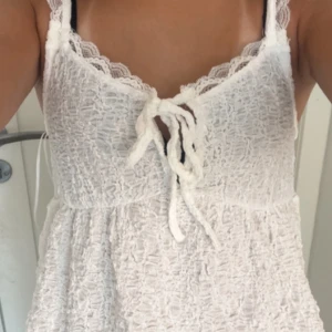 Vit blus med rosett Gina  - Supersöt vit linnetopp från Gina