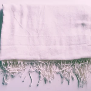 Vit halsduk med fransar - Enkel och stilren vit halsduk med långa fransar i kanterna. Halsduken är mjuk och lätt, perfekt att slänga över axlarna för en clean look. Passar dig som gillar minimalistisk stil och vill ha något som funkar till det mesta. Har 2 likadana  Helt skick dock noppror