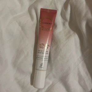 Lumene Natural Glow Skin Tone Perfector - Lumene Natural Glow Skin Tone Perfector i nyansen 4 Berry Blush. Ger en fräsch, naturlig lyster och jämnar ut hudtonen. Kommer i en rosa och vit tub med guldiga detaljer, 20 ml. Vegansk formula och lätt att applicera med smidig tub.