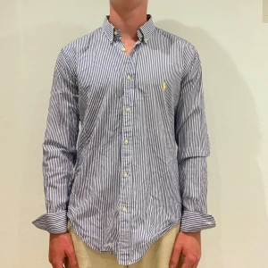 Randig Ralph Lauren Skjorta - Vit/ blå randig Ralph lauren skjorta || Storlek M (Slim Fit) || Skjortan är i bra skick || Mitt pris 599kr || Modellen på bilden är 170cm och väger 62kg || Tveka inte på att höra av dig vid frågor eller funderingar 