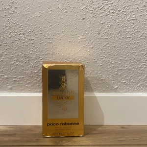 Paco Rabanne 1 Million Lucky 50ml - Paco Rabanne 1 Million Lucky Eau de Toilette, 50ml. Flaskan har en lyxig guldig färg och är formad som en guldtacka med metallisk finish. Förpackningen är också guld- och silverfärgad med tydlig logga. En ikonisk doft med modern design. Drygt halva kvar. Fint skick.