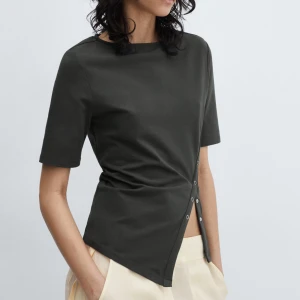 Mörkgrå asymmetrisk topp  - Snygg mörkgrå topp från Mango med kort ärm och unik asymmetrisk knäppning med silverfärgade tryckknappar längs sidan. 