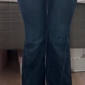 Blå bootcut jeans från Gina Tricot (ordinarie pris 430kr) - Snygga blå jeans från Gina Tricot i bootcut-modell med coola bakfickor med lock och vit kontrastsöm. Jeansen har normal passform och är tillverkade i klassiskt denimtyg. Perfekta för dig som gillar en lite retro vibe och vill sticka ut med detaljer.