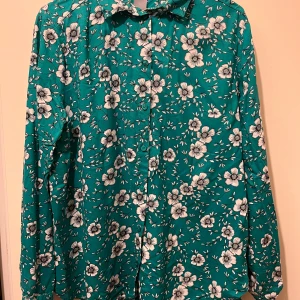 Skjort str M - Blommig skjorta strl M från Lindex. Material: 100% viskos. I nyskick, knappt använd. 