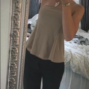 Beige tubtopp🤎 - Säljer en beige tubtopp med ribbad struktur. Har en lätt utsvängd passform och är tillverkad i mjuk bomull. Perfekt för varma dagar och enkel att styla med jeans eller kjol. Har även en slitt i ryggen! Pris kan diskuteras!🤎Är inte använd någon gång! 