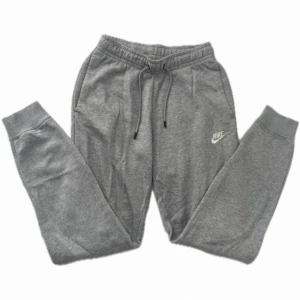 Grå mjukisbyxor från Nike XS - Gråa mjukisbyxor från Nike med klassisk logga på benet. Byxorna har dragsko i midjan, muddar vid bensluten och perfekta för chill eller träning. De är i superbra skick men säljs eftersom de är för små på mig!