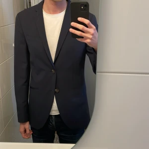 Mörkblå kavaj  - En snygg mörkblå kavaj från Jack and Jones premium som aldrig har använts! Storleken är 46 och den passar mig som är 180 och lite smalare. Nypris var 800 säljer nu för 450:) Hör gärna av er vid frågor!