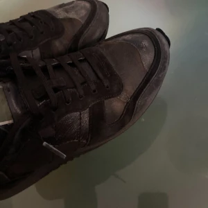 Valentino rockrunners  - Snygga svarta sneakers från Valentino med en stilren design. Skorna har snörning och är tillverkade i en kombination av skinn och syntetmaterial. Perfekta för en trendig look.