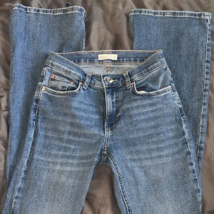 Blå jeans från Gina tricot - Snygga blå jeans från Perfect Jeans med klassisk femficksdesign och knappgylf. Perfekta för en avslappnad stil. De har en rak passform och är tillverkade i slitstarkt denim.