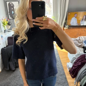 Mörkblå stickad tröja - Säljer en mörkblå stickad tröja med korta ärmar. 