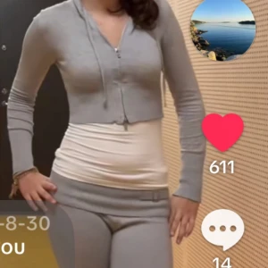 Grå hoodie med matchande byxor - Säljer en grå hoodie med dragkedja och matchande byxor. Hoodien har en ribbad nederkant och långa ärmar. Byxorna har en bred ribbad midja med en dekorativ rosett. Byxorna är lågmidjade och settet är använd fåtal gånger. Inga defekter, från new yorker köpt från plick. Pris kan diskuteras 