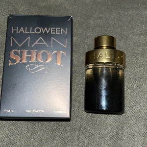 Halloween Man Shot Parfym - Säljer en flaska Halloween Man Shot parfym, 125 ml. Flaskan har en elegant design med en mörk glasflaska och en gyllene kork. Perfekt för den som vill ha en unik och maskulin doft.