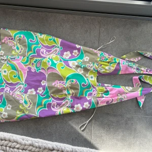 Färgglad klänning från Zara - Mönstrad klänning från zara, är en Stl M men passar small, använd en gång! Halterneck och backless!