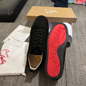 Svarta sneakers från Christian Louboutin - Helt nya svarta sneakers från Christian Louboutin i en stilren design. Skorna har en klassisk snörning och är tillverkade i ett elegant material som ger en lyxig känsla. Perfekta för att lyfta vilken outfit som helst. Varan är ÄKTA med äktehetsbevis. Storleken på skorna är 40 men passar 41. Pris kan diskuteras! 