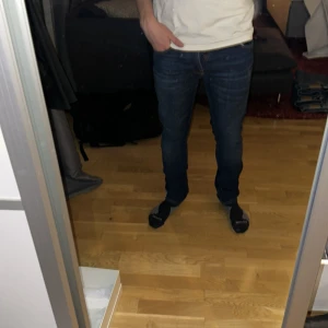 Mörkblå Nudie jeans slim fit - Säljer mina nästan helt nya mörkblå nudie jeans bara använda ett fåtal gånger. Dom var tyvär lite långa för mig!