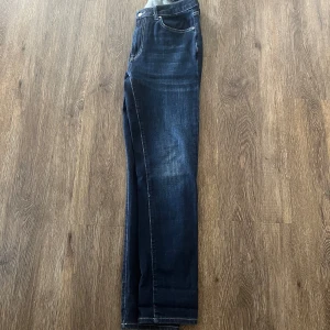 Mörkblå jeans från Dressmann - Snygga mörkblå jeans från Dressmann med en klassisk femficksdesign. De har en slim passform och är perfekta för en stilren look. Jeansen har en dragkedja och knapp framtill. Dem är väldigt sparsamt använda!