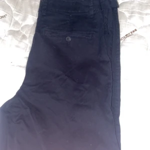 Svarta chinos från Solid - Snygga svarta chinos från Solid med en klassisk design. Byxorna har en knappstängning och är tillverkade i ett bekvämt material som passar perfekt för en stilren look. Köpta för 500kr och använda 1 gång